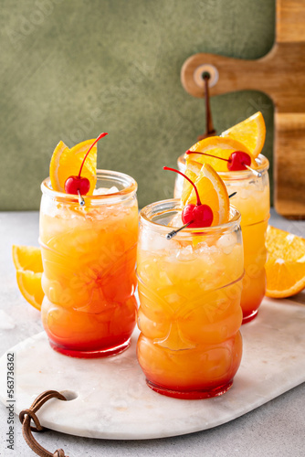 Rum punch in tiki glasses with orange slices and a cherry