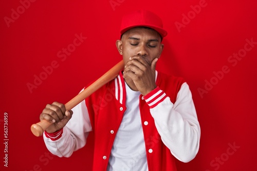 Photography Young hispanic man playing baseball holding bat bored yawning tired covering mouth with hand