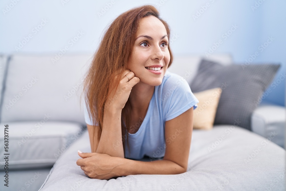 Young woman smiling confident lying on sofa at home Young woman smiling confident lying on sofa at home