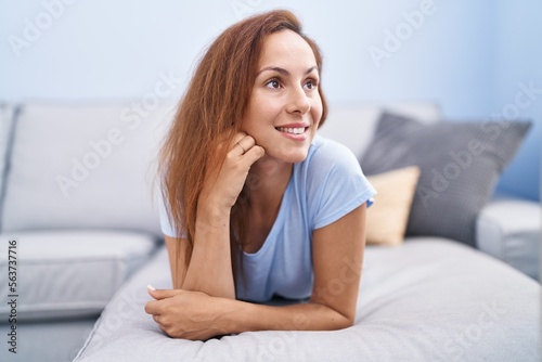Young woman smiling confident lying on sofa at home