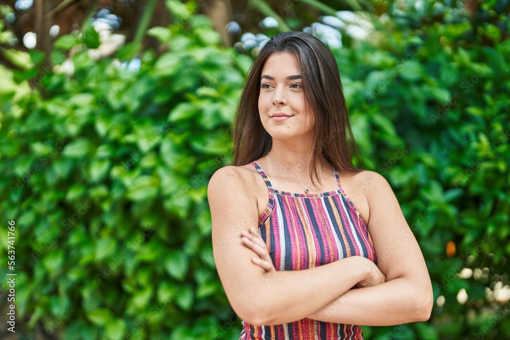 Young beautiful hispanic woman standing with arms crossed gesture at park Young beautiful hispanic woman standing with arms crossed gesture at park