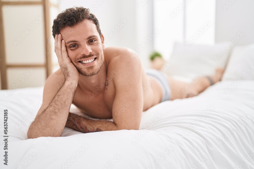 Young hispanic man smiling confident lying on bed at bedroom Young hispanic man smiling confident lying on bed at bedroom