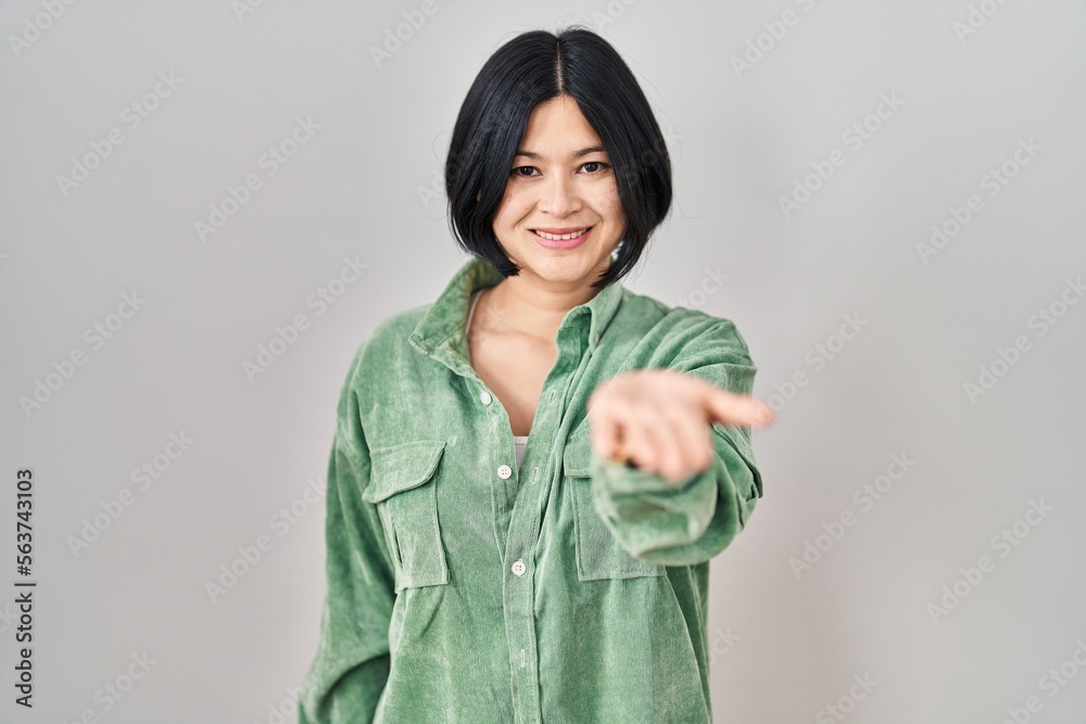 Young asian woman standing over white background smiling cheerful offering palm hand giving assistance and acceptance. Young asian woman standing over white background smiling cheerful offering palm hand giving assistance and acceptance.
