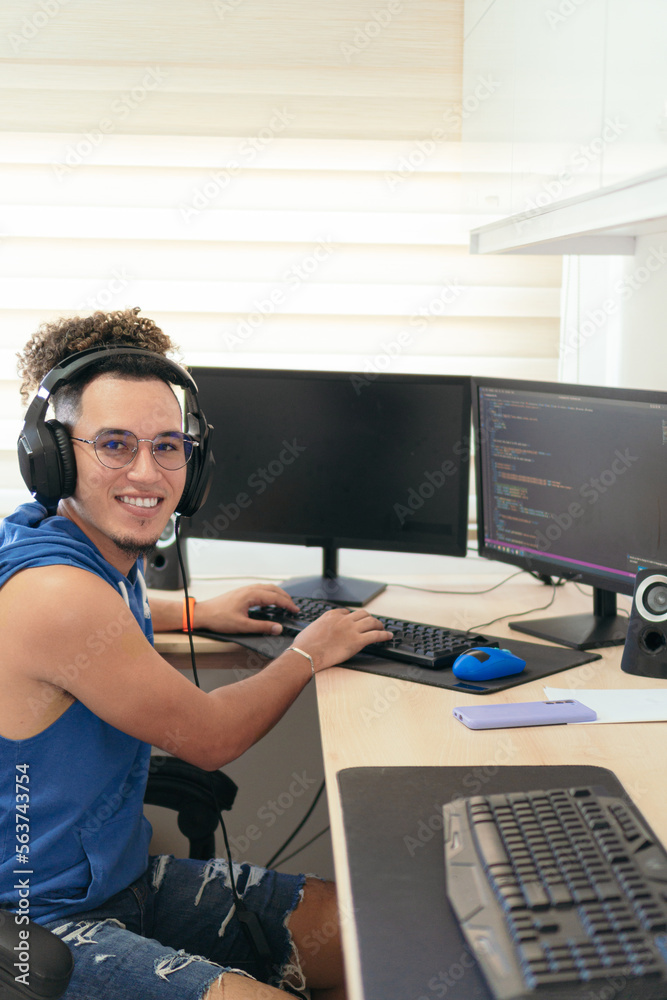 male programmer in casual clothes working on the computer at the table. male programmer in casual clothes working on the computer at the table.