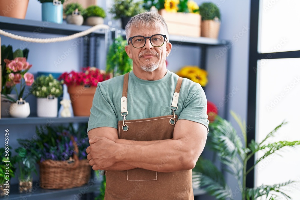 Middle age grey-haired man florist smiling confident standing with arms crossed gesture at flower shop Middle age grey-haired man florist smiling confident standing with arms crossed gesture at flower shop