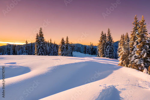 Winter mountain blanketed in a pristine, snow-dusted landscape, with trees dusted in an ethereal white frost. A blazingly warm sunset illuminated the early-night sky, Generative AI