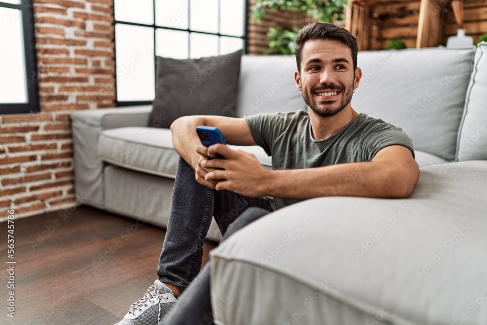 Young hispanic man smiling confident using smartphone at home Young hispanic man smiling confident using smartphone at home