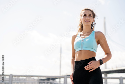 Using a smartwatch and an app for running on your hands, calorie count and pulse. The trainer is a runner, a brunette woman who trains in fitness clothes.