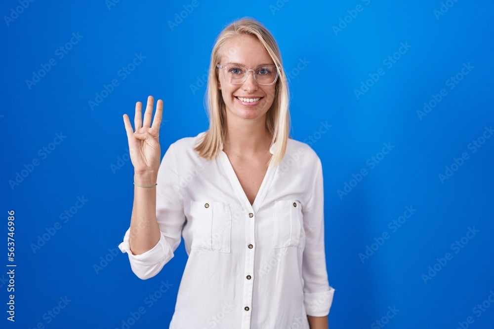 Young caucasian woman standing over blue background showing and pointing up with fingers number four while smiling confident and happy. Young caucasian woman standing over blue background showing and pointing up with fingers number four while smiling confident and happy.