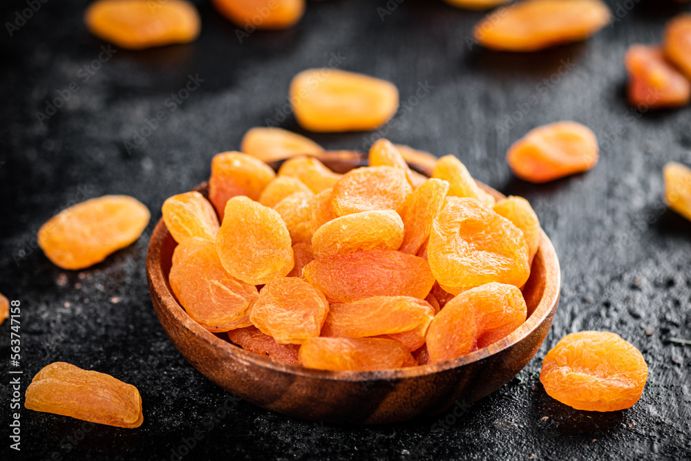 Dried apricots in a wooden plate on the table. Dried apricots in a wooden plate on the table.
