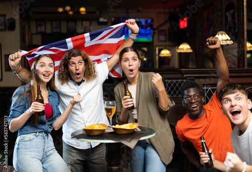 International group of people with UK flag toasting with beer, having fun at party in nightclub