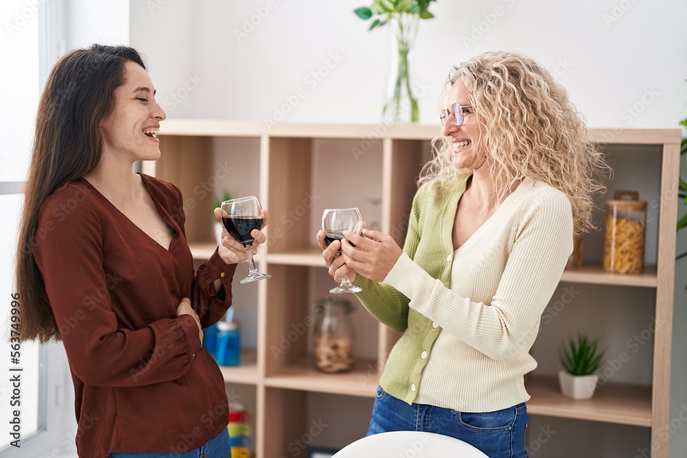 Two women mother and daughter drinking wine at home Two women mother and daughter drinking wine at home