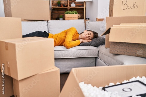 Young caucasian woman doing yoga exercise sitting on sofa at new home