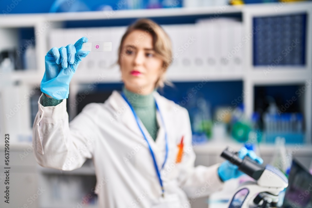 Young woman scientist using microscope looking sample at laboratory Young woman scientist using microscope looking sample at laboratory