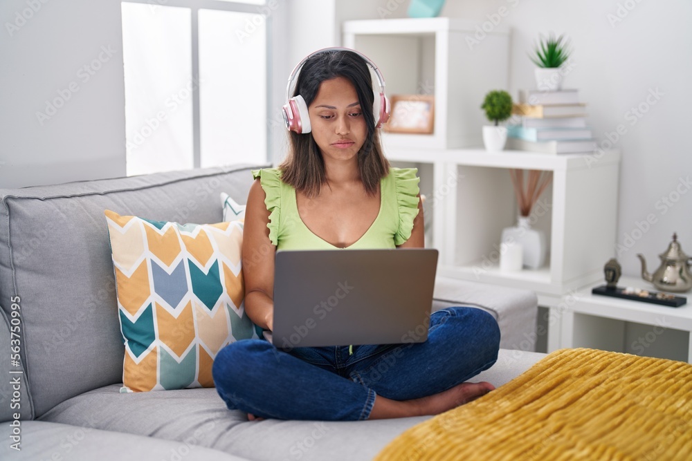 Hispanic young woman using laptop at home depressed and worry for distress, crying angry and afraid. sad expression. Hispanic young woman using laptop at home depressed and worry for distress, crying angry and afraid. sad expression.