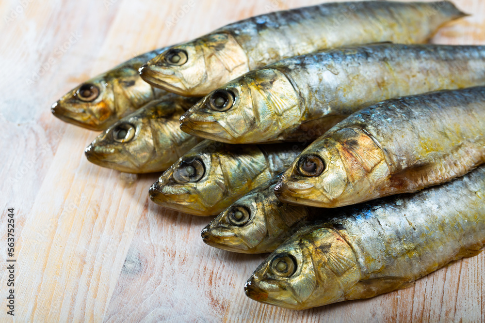 Obraz premium Closeup of salted sardines on wooden surface. Food background..