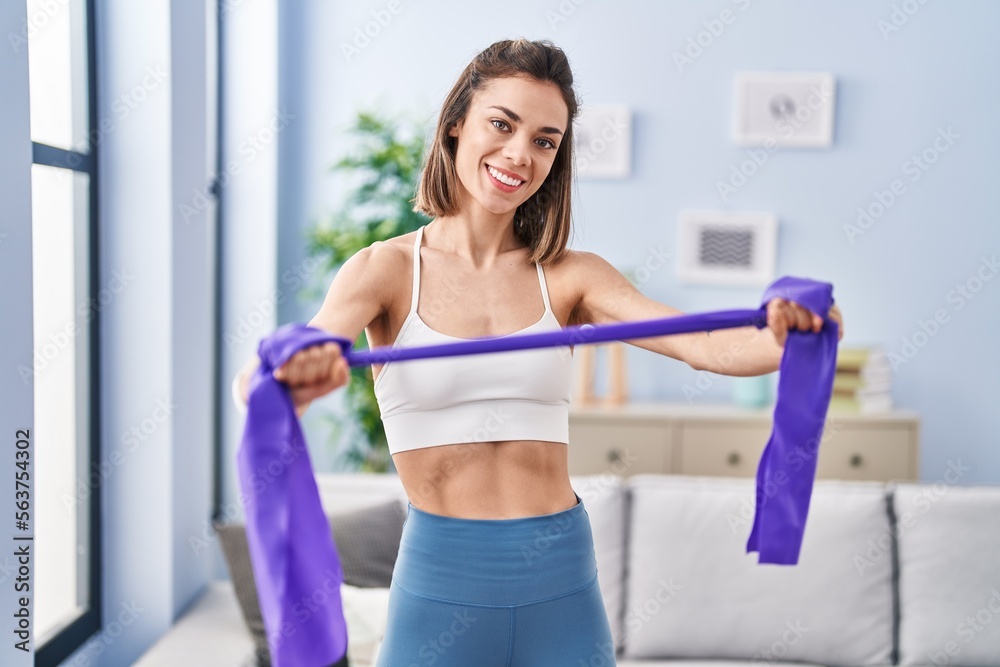 Young beautiful hispanic woman smiling confident using elastic band training at home Young beautiful hispanic woman smiling confident using elastic band training at home