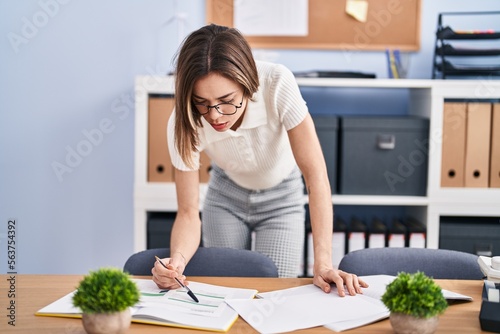 Young beautiful hispanic woman business worker reading document working at office © Krakenimages.com