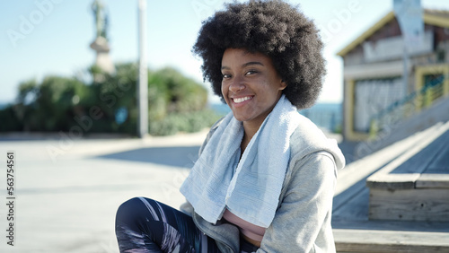 African american woman wearing sportswear sitting on bench at street