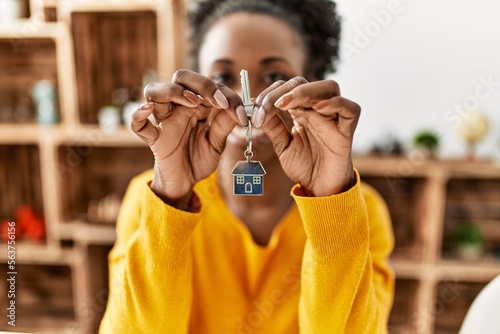African american woman smiling confident holding key of new house at home