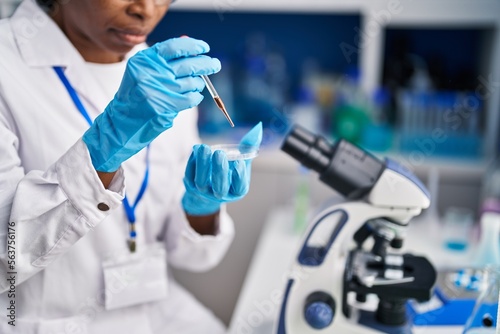 Fototapeta Naklejka Na Ścianę i Meble -  African american woman wearing scientist uniform working laboratory