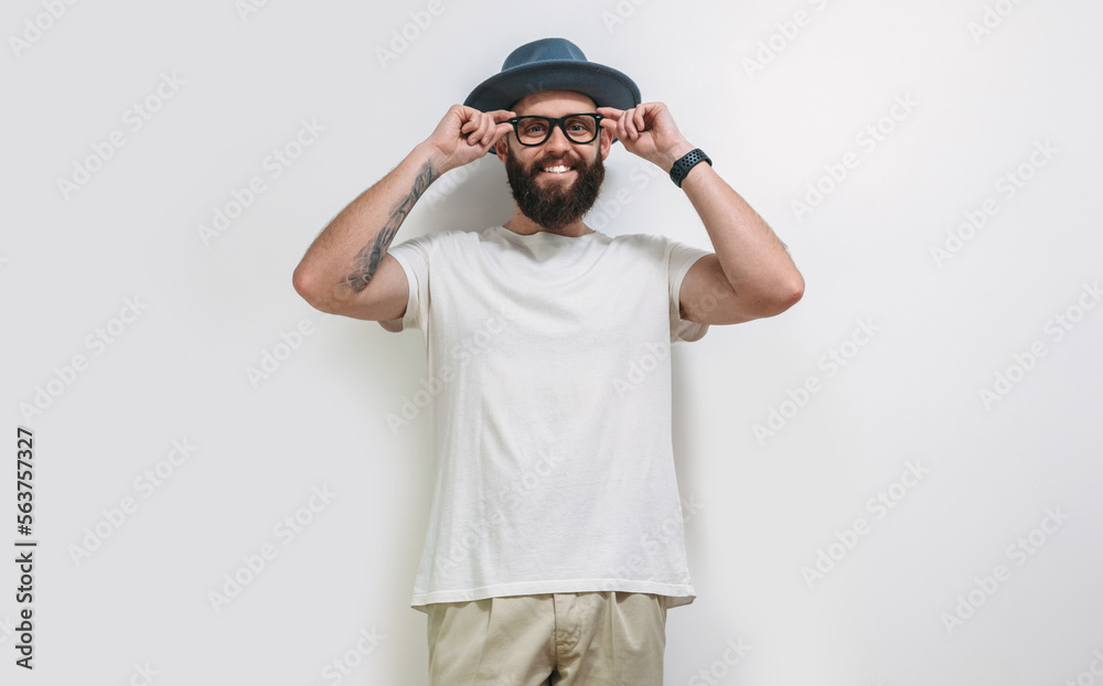 Young bearded hipster guy wearing white blank t shirt with copy space for your text or logo. Mockup for design Young bearded hipster guy wearing white blank t shirt with copy space for your text or logo. Mockup for design
