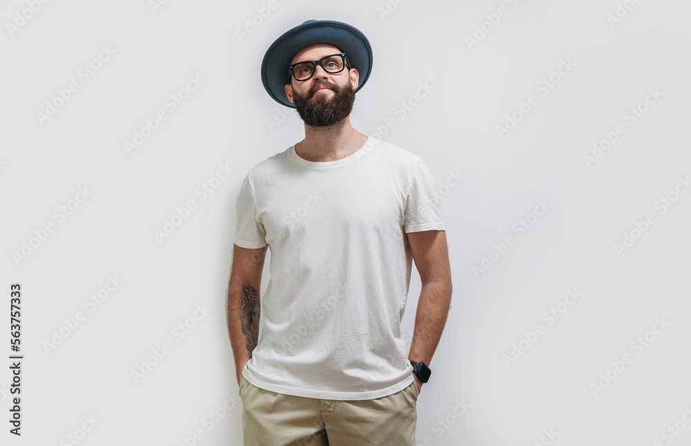 Young bearded hipster guy wearing white blank t shirt with copy space for your text or logo. Mockup for design Young bearded hipster guy wearing white blank t shirt with copy space for your text or logo. Mockup for design