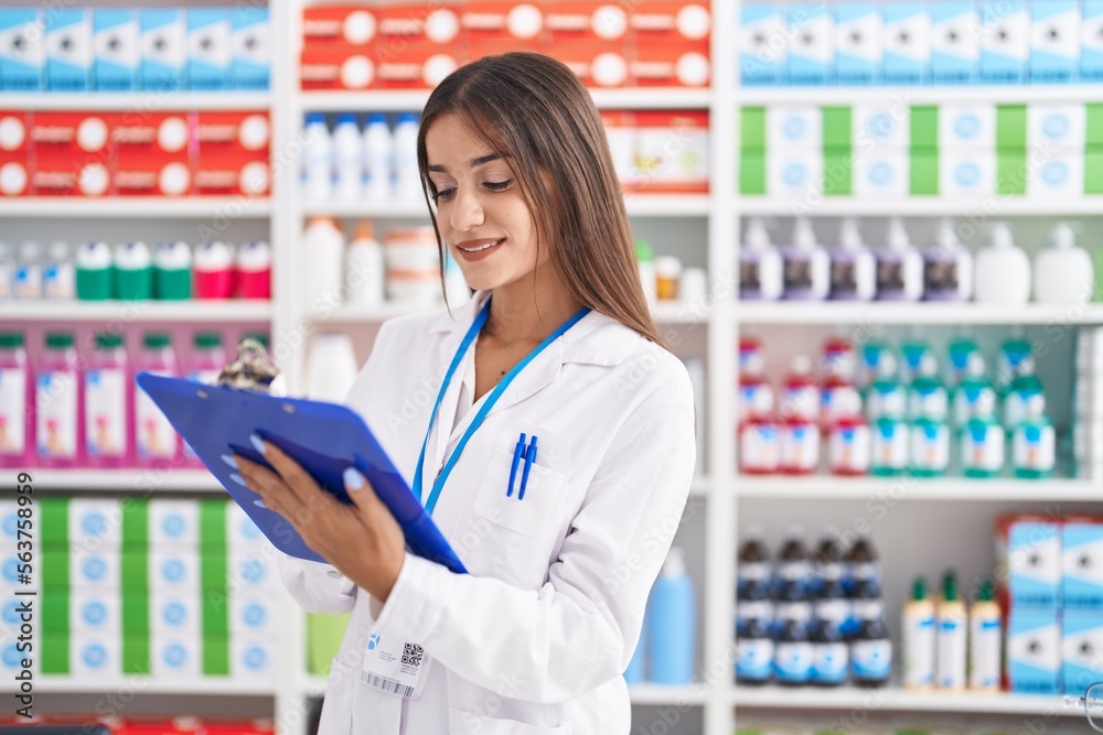 Young beautiful hispanic woman pharmacist smiling confident writing on document at pharmacy Young beautiful hispanic woman pharmacist smiling confident writing on document at pharmacy