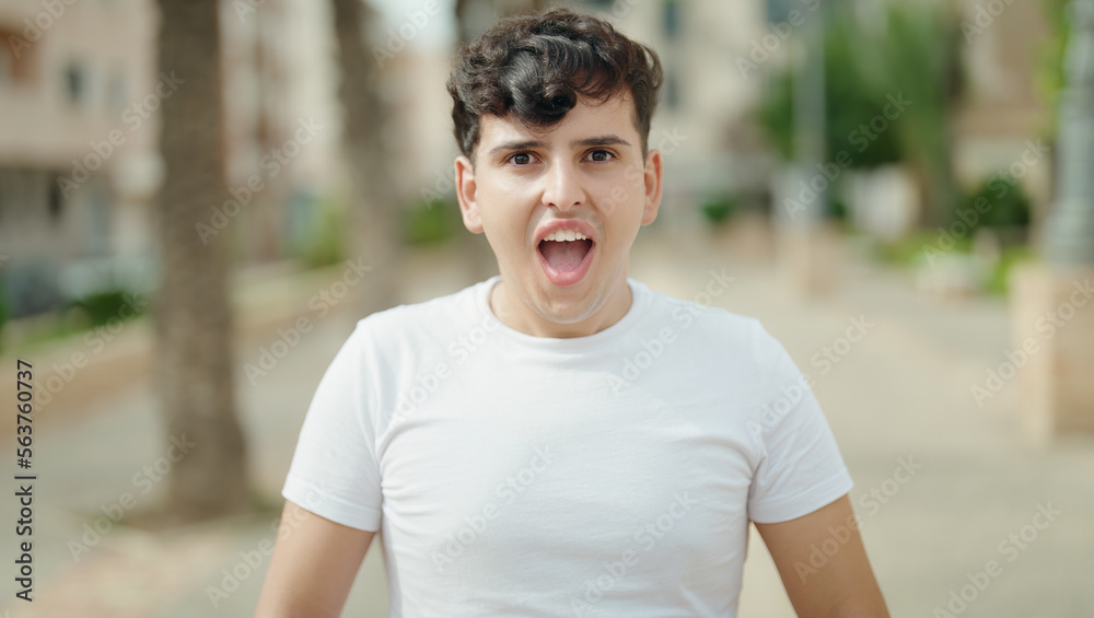 Non binary man standing with surprise expression at park