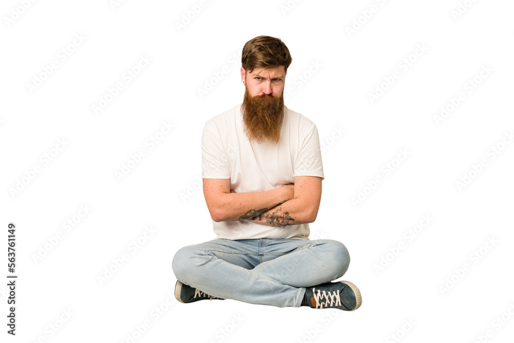 Young adult redhead with a long beard sitting on the floor isolated unhappy looking in camera with sarcastic expression. Young adult redhead with a long beard sitting on the floor isolated unhappy looking in camera with sarcastic expression.