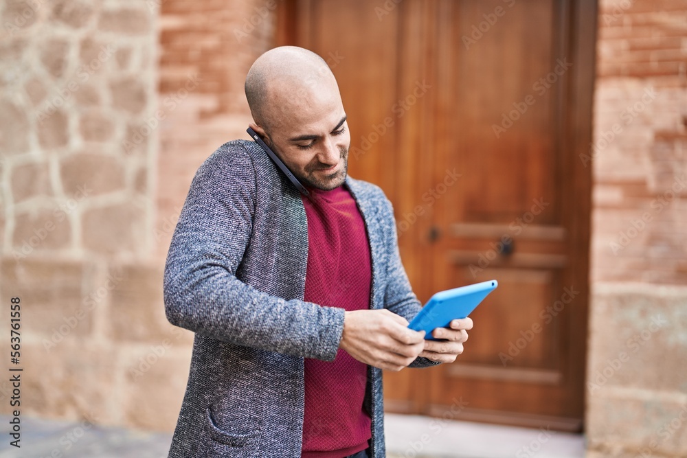 Obraz premium Young man talking on the smartphone using touchpad at street