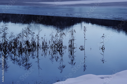 Landscape photo of frozen lake in winter. The ice gives an artistic impression. Winter morning photo. dark impression.