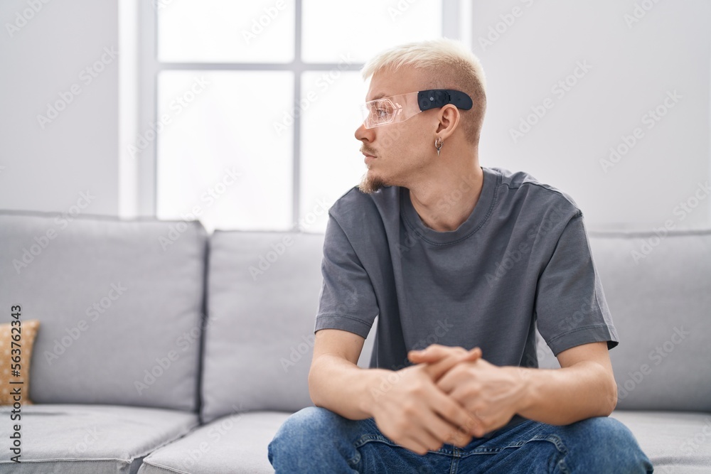 Young caucasian man wearing virtual reality glasses looking to side, relax profile pose with natural face with confident smile.