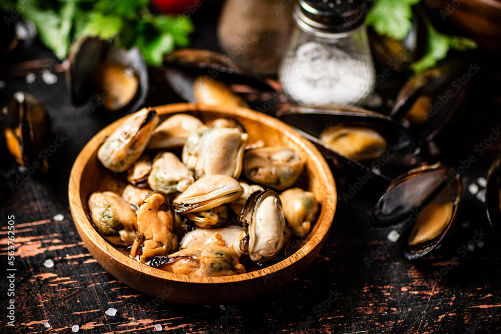 Fototapeta premium Pickled mussels in a wooden plate on the table. 