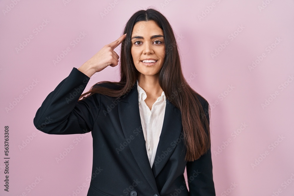 Young brunette woman wearing business style over pink background smiling pointing to head with one finger, great idea or thought, good memory Young brunette woman wearing business style over pink background smiling pointing to head with one finger, great idea or thought, good memory