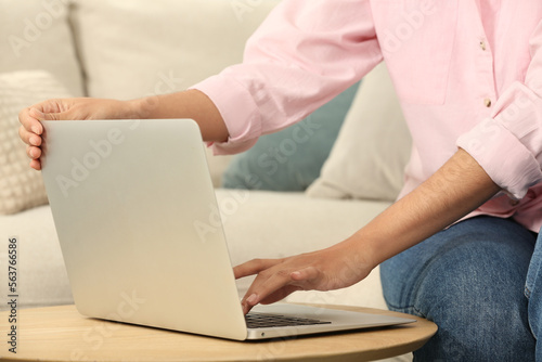 African American woman typing on laptop at table indoors, closeup