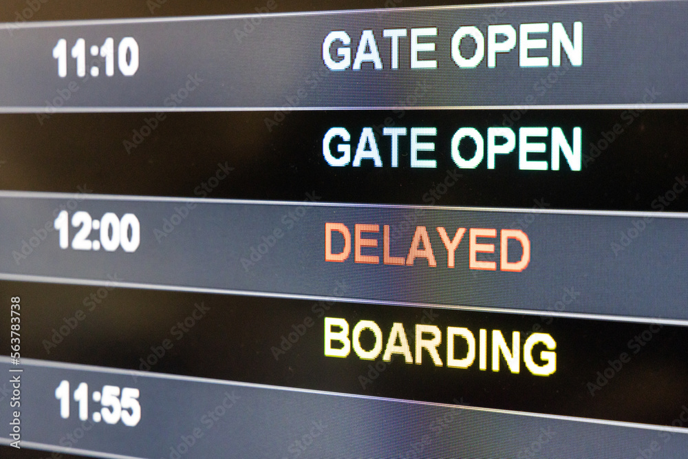 Close-up on airport flight information digital board with focus on word Delayed, Gate Open, Boarding Close-up on airport flight information digital board with focus on word Delayed, Gate Open, Boarding