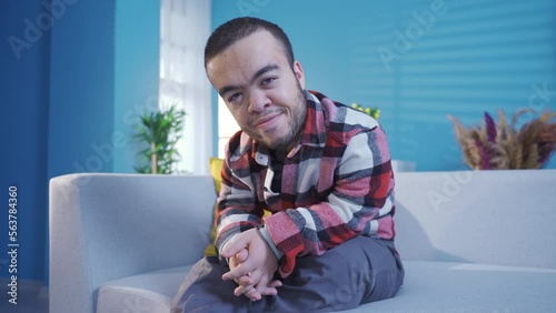 Dwarf young man at home looking at camera happily and resolutely, confident and brave.
Close-up portrait of happy and confident disabled young man with dwarfism.
 photo