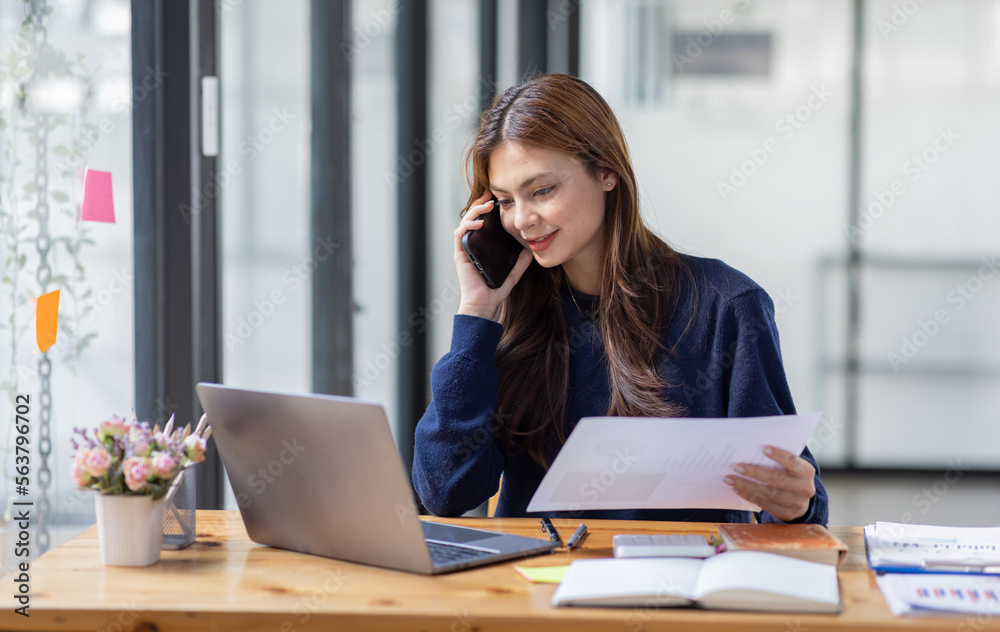 Cheerful business Asian woman freelancer making telephone call share good news about project working in office workplace, business finance concept. Cheerful business Asian woman freelancer making telephone call share good news about project working in office workplace, business finance concept.
