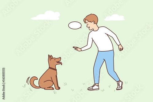 Smiling boy play with dog outdoors 