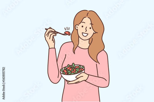Smiling woman eating salad 