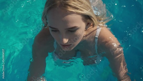 Top view video of beautiful girl in swimsuit posing in outdoor swimming pool