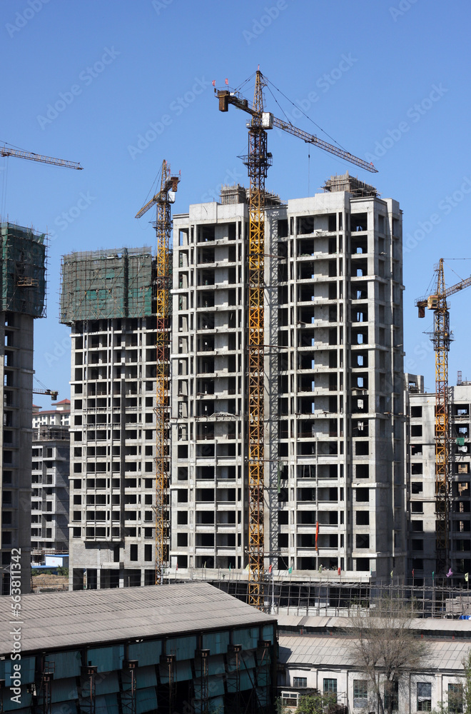 Crane and building construction site against blue sky 
