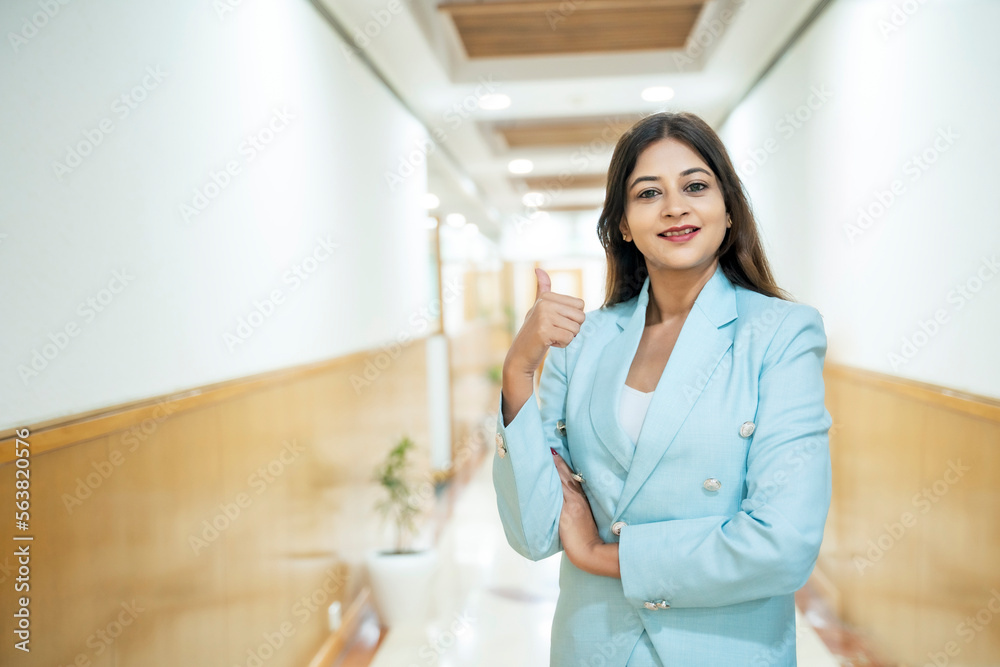 Indian corporate woman showing thumps up at office Indian corporate woman showing thumps up at office