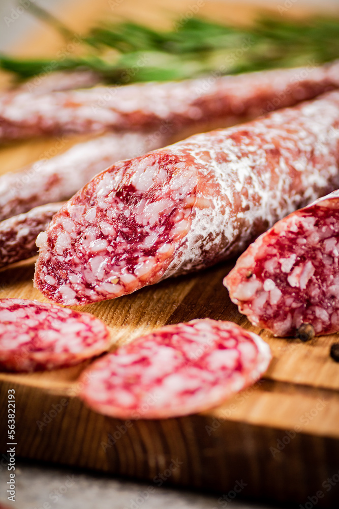 Pieces of salami sausage on a cutting board. Pieces of salami sausage on a cutting board.