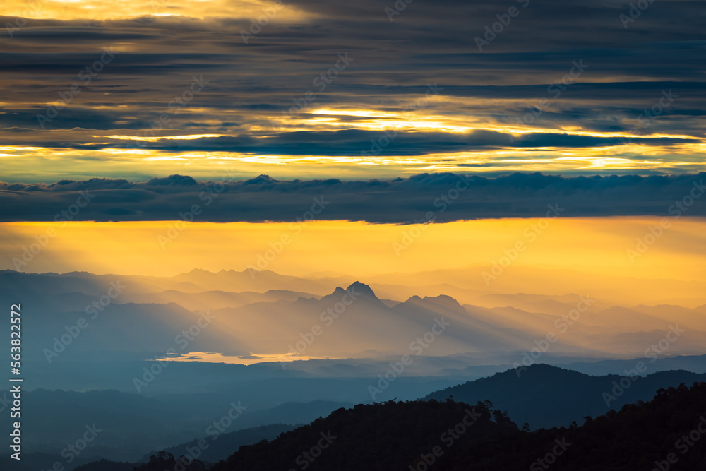 Sunlight hitting the mountain peak with dramatic sky in the northern of thailand