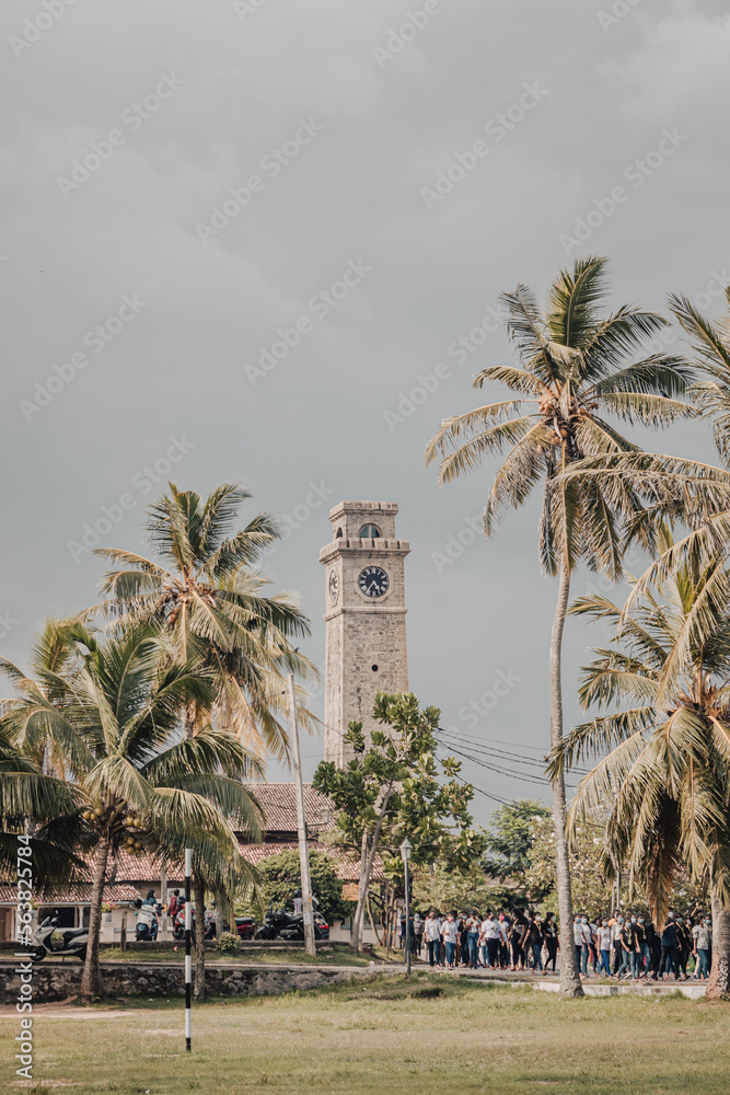 Clock Tower of Galle Fort with palm trees on a sunny day