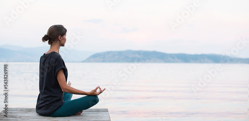 Beautiful woman practicing yoga near the sea panoramic banner, Young girl meditate at sunset, Harmony, meditation, healthy lifestyle and travel concept