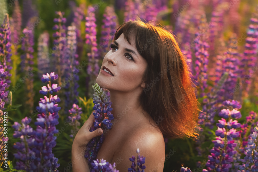 woman brunette with bouquet of flowers in lupine field enjoys sun woman brunette with bouquet of flowers in lupine field enjoys sun