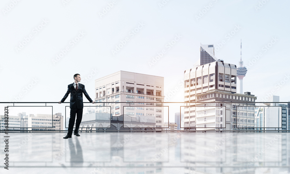 Sunrise above skyscrapers and businessman facing new day